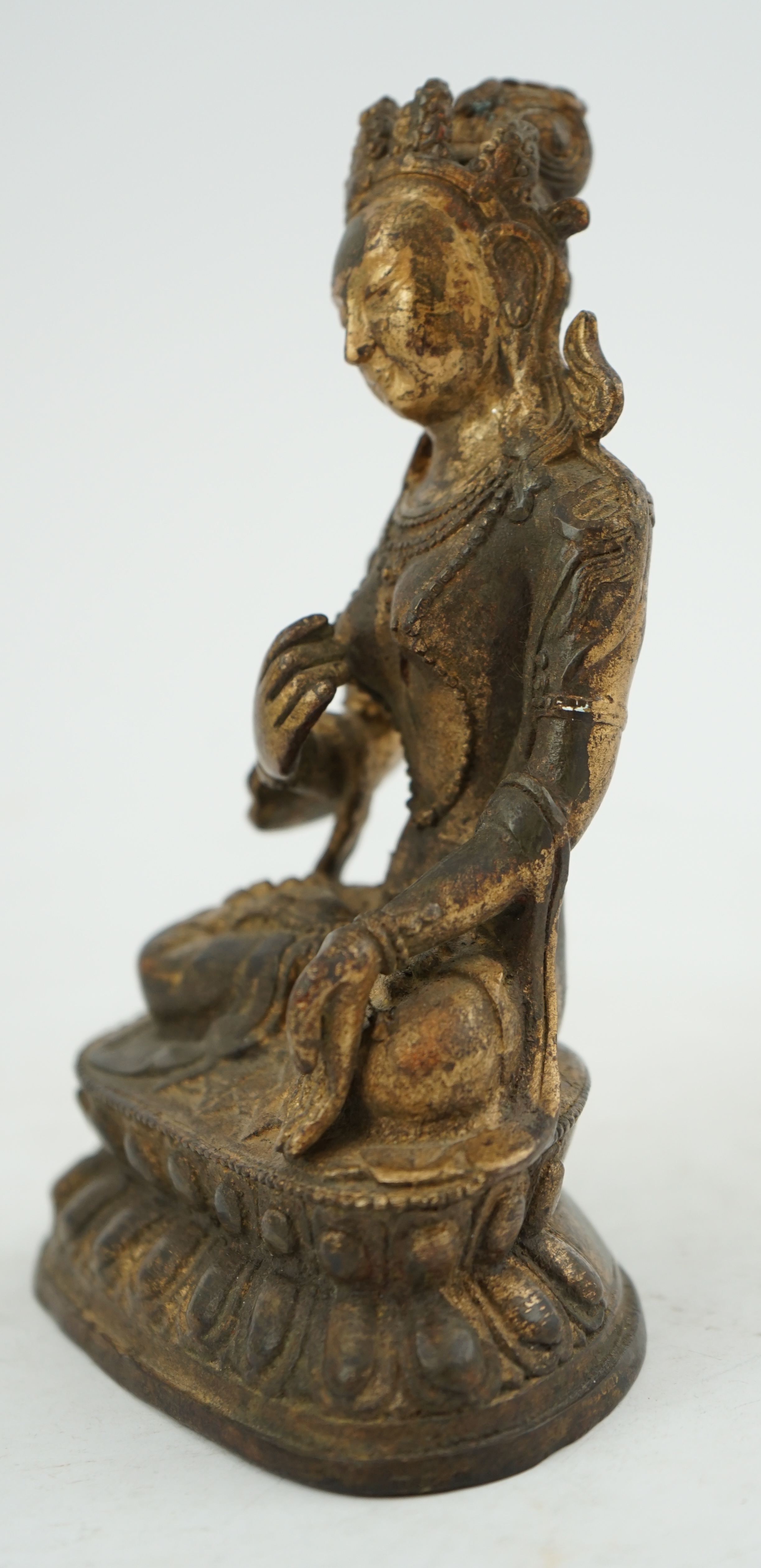 A Tibetan gilt bronze figure of seated Tara, on a double lotus throne, 16.5cm high. Condition - good